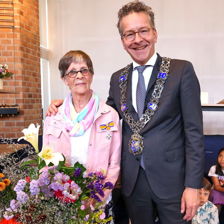 Lia van Buuren-Roosenbrand poseert met de burgemeester na uitreiking van het lintje, klik voor een vergroting