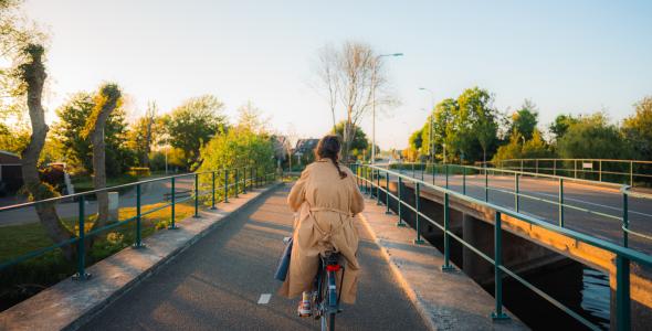 Vrouw fietst over brug